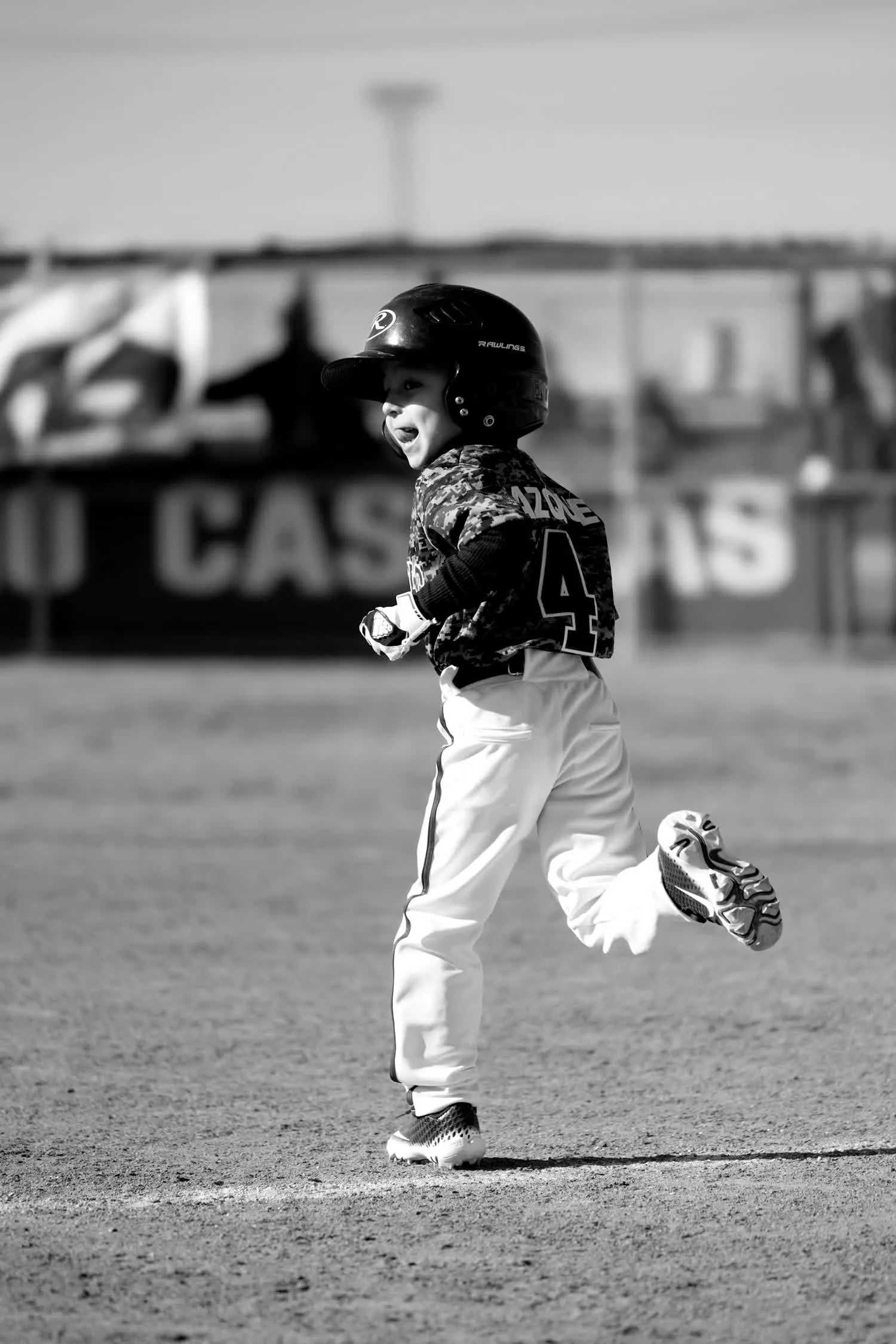 A little-league player running the bases, grinning
